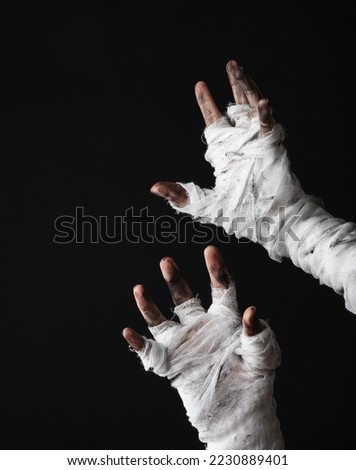 Mummy hands wrapped in a bandage isolated on a black background. Halloween concept
