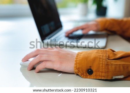 Close-up woman searching and clicking mouse using laptop, online shopping concept. Blurred background