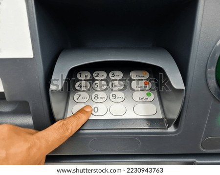 Closeup of male hands typing at ATM, bank machine