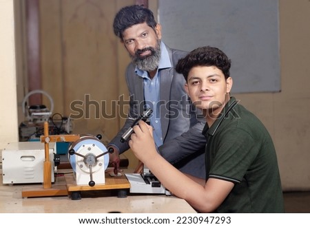 Indian male teacher and student working or experimenting in science lab.
