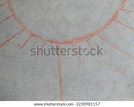 hand drawn Sunrays art at home. sun drawing and chalks on asphalt. Red Sun sketched by shattered brick on surface. A red sun shape picture has been made on the ground with a piece of brick.
