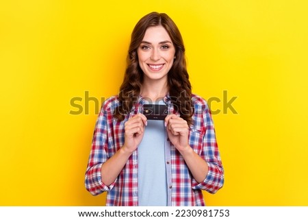 Photo of cute charming girl dressed checkered shirt holding showing debit card isolated yellow color background