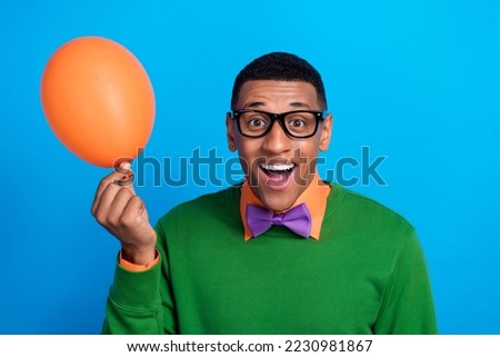 Closeup portrait photo of excited funky student guy wear purple bowtie hold helium air balloon birthday greetings isolated on blue color background