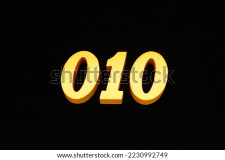  Golden Arabic numerals 010, 1 cm thick, visible in 3D on a black velvet background.                               