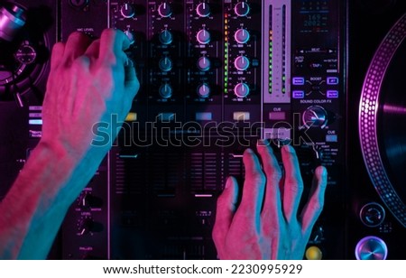 Club DJ mixing music with sound mixer device. Overhead photo of disc jockey playing set on party in the club. Disk jokey plays hip hop in nightclub Royalty-Free Stock Photo #2230995929