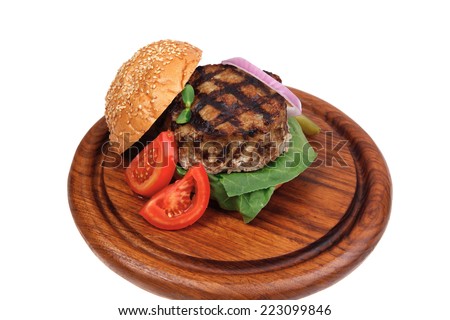 extra thick hot beef meat hamburger dinner on wooden plate with tomatoes and salad isolated on white background