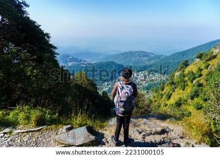 Guy with a Backpack Standing and Admiring the Cityscape of Dharamshala, Triund Hill, Indrahar Pass Trail, Dauladhar Range, Himachal Pradesh, India Royalty-Free Stock Photo #2231000105