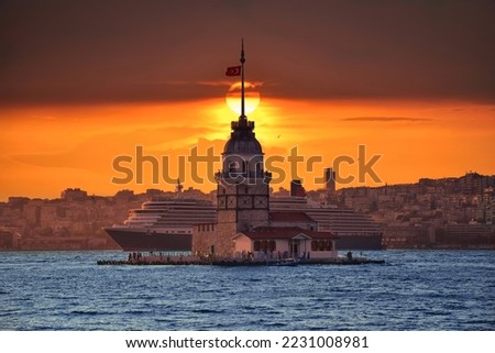 Fiery sunset over Bosphorus with famous Maiden's Tower (Kiz Kulesi) also known as Leander's Tower, symbol of Istanbul, Turkey. Scenic travel background and cruise ship for wallpaper or guide book . Royalty-Free Stock Photo #2231008981