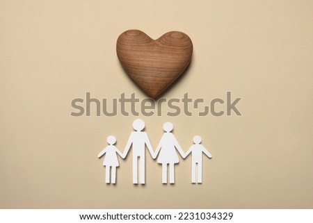Paper family figures and wooden heart on beige background, flat lay. Insurance concept