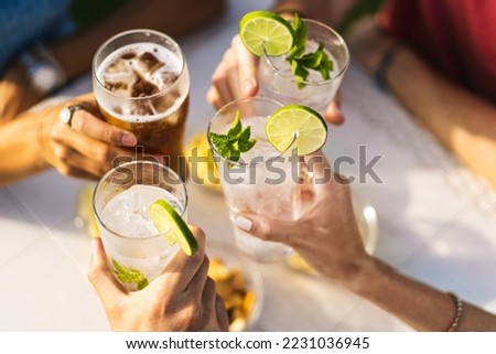 Group of people celebrating toasting with cocktails - cropped detail with focus on hands - lifestyle concept of people, drinks and alcohol - no faces - unrecognizable people Royalty-Free Stock Photo #2231036945