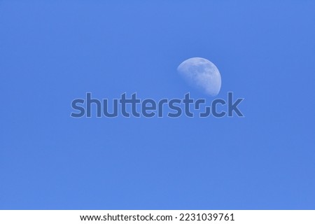 A picture of half moon in the sky