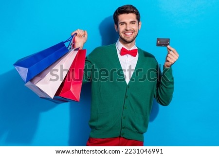 Photo of positive attractive man rejoice holiday purchase showing card online nfc payment isolated on blue color background