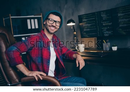 Photo of happy smiling freelancer wear hat glasses creating block chain modern gadget indoors workplace workstation loft