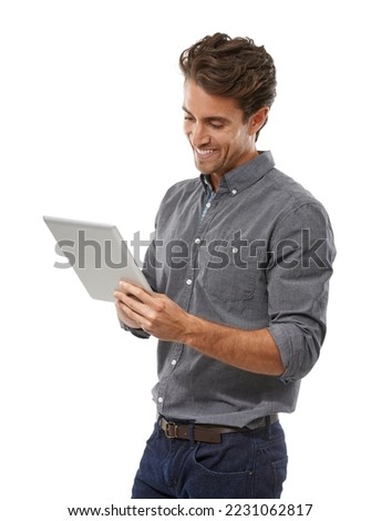 Enjoying the benefits of tablet technology. A handsome young man working on his digital tablet. Royalty-Free Stock Photo #2231062817