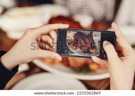 Phone, photograph and thanksgiving with the hands of a woman taking a picture of food on a dinner table. Mobile, social media and Christmas with a female using her smartphone to photo a roast meal