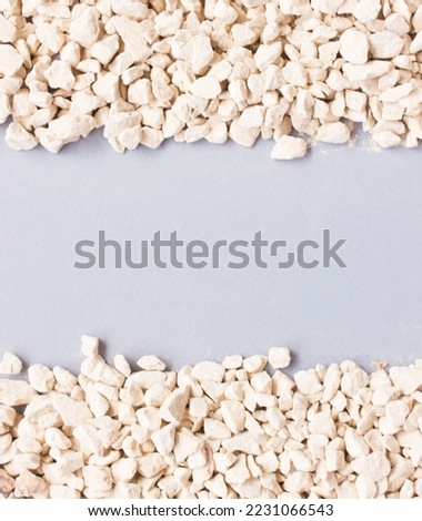 white gravel on blue grey background. Concept of material for construction. Free copy space