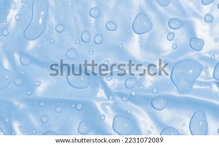 water drops on blue background. Waterproof fabric. Summer wallpaper.