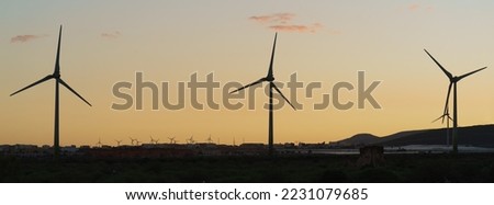 Image of wind turbines as alternative eco-friendly energy source at Gran Canaria. Modern technology theme. Photography in silhouettes with sunset sky as background