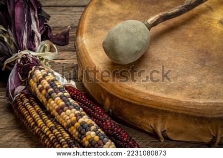 handmade, native American style, shaman frame drum covered by goat skin with a beater or a rustic wood with ornamental corn Royalty-Free Stock Photo #2231080873