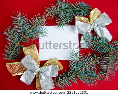 Christmas composition on red background. Paper blank, christmas tree branches and christmas decorations. Copy space for text. Flatlay for designers. Top view, Greeting Card mock up.