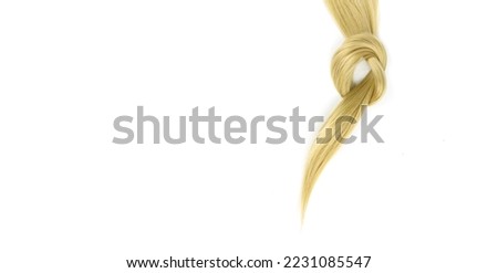 Strand of honey blonde hair lock tied in knot on white background, top view. Hair extensions, materials and cosmetics, hair care, wig Royalty-Free Stock Photo #2231085547