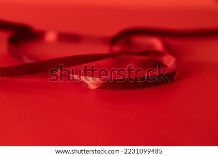 Close-up of a red ribbon on a red background. Sewing accessory.