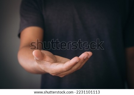 The man is standing and shows an outstretched hand with an open palm. Businessman showing empty hand and presenting with hand empty copy space. Open hand, Holding, giving, showing, presenting concept. Royalty-Free Stock Photo #2231101113
