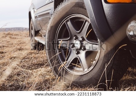 Car stands on a dirt road during the day