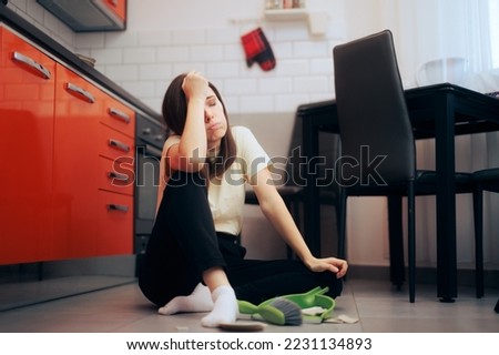 
Unhappy Woman Cleaning up After Broken Plate Incident. Sad girl having an accident in the kitchen 
 Royalty-Free Stock Photo #2231134893