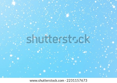 Winter holidays and wintertime background, white snow falling on blue backdrop, snowflakes bokeh and snowfall particles as abstract snowing scene for Christmas and snowy holiday design. High quality