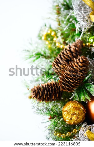 Christmas decoration with fir branches, golden and silver baubles and cones. Vertical composition over white background, space for your text.