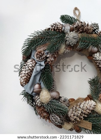 Christmas Wreath on white background. Handmade New Year's home wall decor banner design. Pine branches, cones, leaves, beads and snowflakes. Holiday Decoration Christmas decor self made closeup