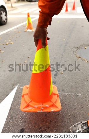 a worker sets up a traffic cone