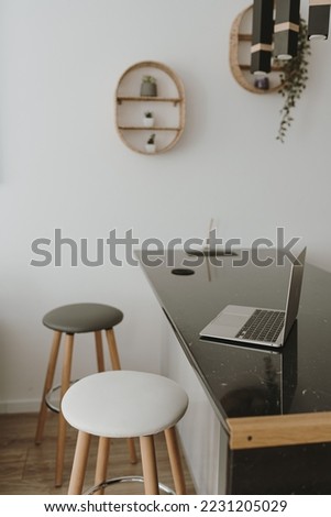 Laptop computer on bar counter and stools. Interior decoration details. Modern aesthetic minimalist home living room interior design. Work at home, outsourcing workspace