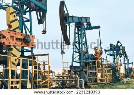 Oil Pump Jacks. Country road and Oil pumps, nodding donkey or pump jack and rig.