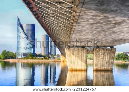 View under Vansu bridge in Riga, Latvia. Modern building left and pillars of the bridge right 