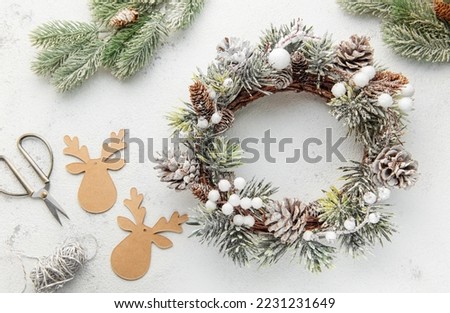 Decorative festive Christmas wreath. Wreath made of fir tree and cones on a grey concrete background. Christmas decorations
