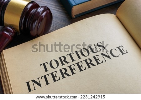 Open book and gavel. Tortious interference concept. Royalty-Free Stock Photo #2231242915