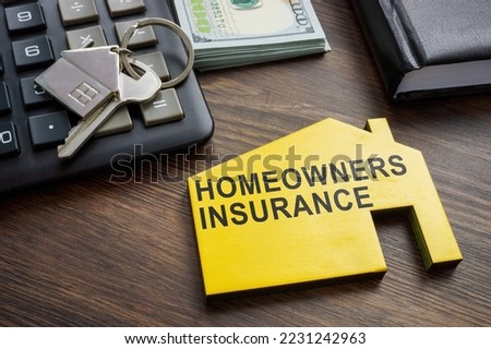 Homeowners insurance inscription on the wooden home. Royalty-Free Stock Photo #2231242963