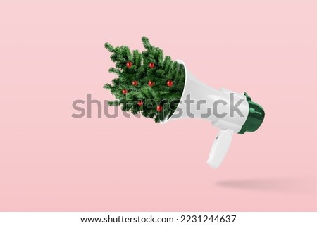 Creative composition made of megaphone with Christmas trees on pink background. Minimal Christmas or New Year concept.
