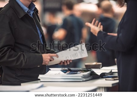 Business people exchanging business promotional materials and brochure on business meeting on trade-show. Business discussion talking deal concept Royalty-Free Stock Photo #2231251449