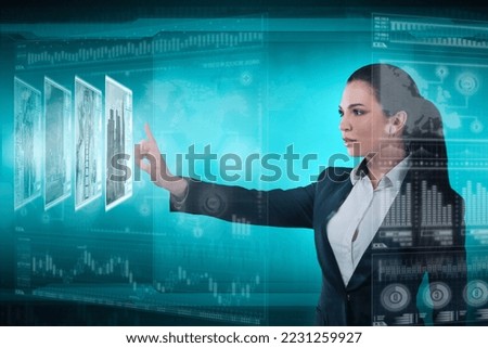 Young business lady works with virtual graphic interface in futuristic office