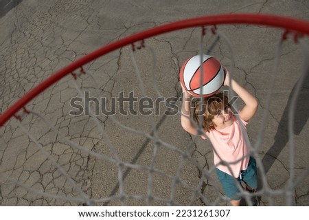 Little child boy playing basketball with basket ball. View of flying ball to basket from top, kid play basketball.