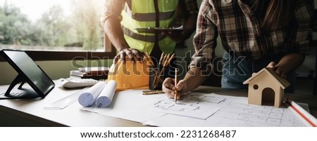 Engineer Teamwork Meeting, Drawing working on blueprint meeting for project working with partner on model building and engineering tools in working site, Construction and structure concept. Royalty-Free Stock Photo #2231268487