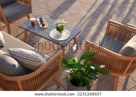 wooden sofa and metal table in yard, patio of beautiful house in the garden,close up