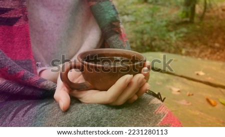 A clay pot with tea in the forest, cozy picture