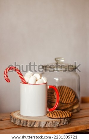 Christmas or New Year mockup of mug. White and red mug with candy cane, marshmallows and cookies. Template for mug design