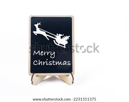 small black chalk board with happy Christmas message and flying Father Christmas graphic on a white background 
