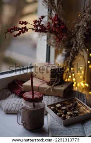 Cocoa in a cup against the background of chocolates and garland