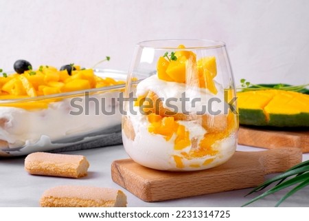 Trifle dessert with mango and ladyfinger cookies served in a glass. Tiramisu cake variation Royalty-Free Stock Photo #2231314725